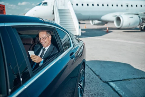 A business man sitting in a limo at airport